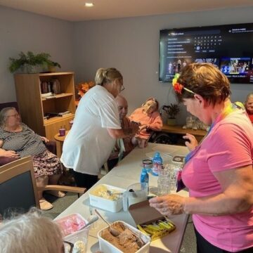 Photo of Norma and Sue making Ice Cream sundaes with residents