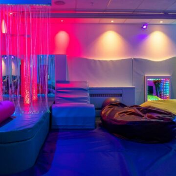 Sensory room with red yellow and green soft lighting and soft furnishings