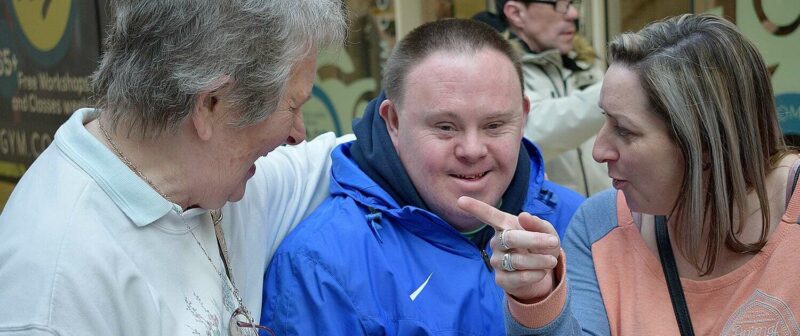 A service user and two adults smiling